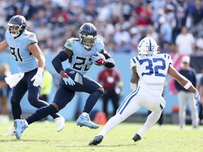 Derrick Henry of the Tennessee Titans runs with the ball against Julian Blackmon of the Indianapolis Colts during the second half at Nissan Stadium on October 23, 2022 in Nashville, Tennessee.