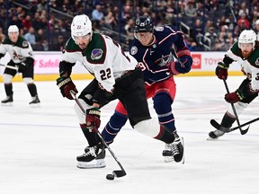 Jack McBain of the Arizona Coyotes controls the puck against Patrik Laine of the Columbus Blue Jackets during the first period at Nationwide Arena on October 25, 2022 in Columbus, Ohio.
