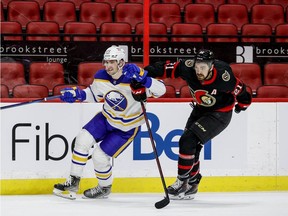 Ottawa Senators left wing Nick Paul (21) and Buffalo Sabres defenseman Mattias Samuelsson (23) during third period NHL action at the Canadian Tire Centre. January 18,2022.