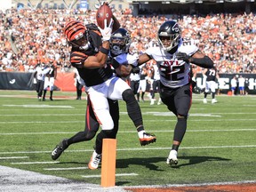 Ja'Marr Chase of the Cincinnati Bengals reaches for a touchdown after making a catch while defended by Cornell Armstrong (C) and Jaylinn Hawkins of the Atlanta Falcons.