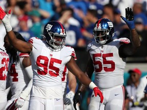Quincy Roche #95 and Jihad Ward #55 of the New York Giants react after a stop in the fourth quarter against the Jacksonville Jaguars.