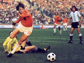 (FILES) This file photo taken on June 26, 1974 shows Dutch midfielder Johann Cruyff dribbling past Argentinian goalkeeper Daniel Carnevali on his way to scoring a goal during the World Cup quarter-final soccer match between the Netherlands and Argentina on June, 26, 1974 in Gelsenkirchen. FILE / Getty Images