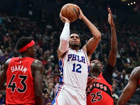 Philadelphia 76ers forward Tobias Harris (12) shoots the ball over Toronto Raptors forwards Pascal Siakam (43) and Chris Boucher (25) in the first half at Scotiabank Arena on Wednesday night.