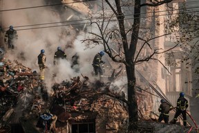 Ukrainische Feuerwehrleute arbeiten an einem zerstörten Gebäude nach einem Drohnenangriff in Kiew am 17. Oktober 2022 inmitten der russischen Invasion in der Ukraine.  (Foto von YASUYOSHI CHIBA/AFP über Getty Images)