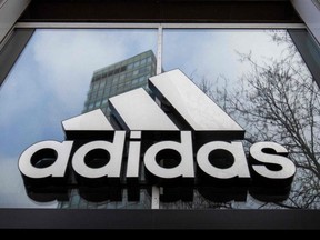 In this file photo taken March 29, 2020, The logo of German sporting goods company Adidas is pictured at one of the company's outlets in Berlin.