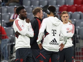 Alphonso Davies chats with his Bayern Munich teammates before a match against SC Freiburg at Allianz Arena in Munich, Germany, Sunday, Oct. 16, 2022.