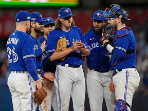 Oct 8, 2022; Toronto, Ontario, CAN; Toronto Blue Jays starting pitcher Kevin Gausman is surrounded by teammates before he gets pulled in the sixth inning against the Seattle Mariners during game two of the Wild Card series for the 2022 MLB Playoffs at Rogers Centre.