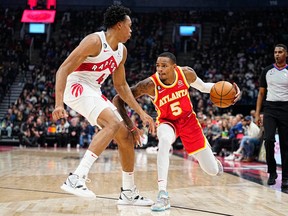 Atlanta Hawks' Dejounte Murray (right) drives to the net against Raptors' Scottie Barnes during the first half at Scotiabank Arena on Monday, Oct. 31, 2022.