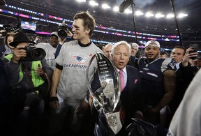 New England Patriots owner Robert Kraft, center, carries the trophy with his team’s then quarterback Tom Brady as they leave the field after the 2018 AFC championship game.