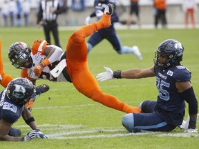 B.C. Lions running back James Butler  is brought down by Toronto Argonauts' Robert Priester (left) and Brandon Barlow during first half of CFL football action in Toronto on Saturday October 8, 2022.