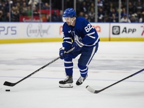 Toronto Maple Leafs centre Denis Malgin moves the puck forward while defended by Detroit Red Wings defencemen Wyatt Newpower during second period NHL pre-season action,  in Toronto, on Saturday, Oct. 8, 2022.