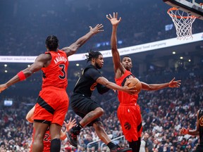 Darius Garland (10) of the Cleveland Cavaliers drives to the net between OG Anunoby (3) and Christian Koloko (35) of the Toronto Raptors during the first half of their season opener on Wednesday night at Scotiabank Arena.