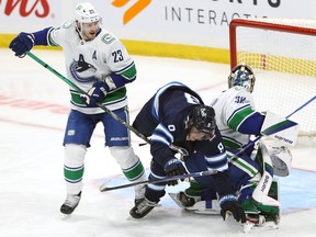 The Winnipeg Jets and  Vancouver Canucks battle during a game last season.