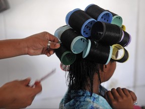 A 12-year-old girl has her hair straightened at a beauty salon in Boca Chica, Dominican Republic on Sept. 28, 2013.