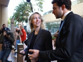 Former Theranos CEO Elizabeth Holmes arrives at federal court with her partner Billy Evans on Oct. 17, 2022 in San Jose, Calif.