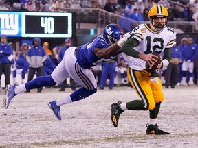 Dec 1, 2019; East Rutherford, NJ, USA; Green Bay Packers quarterback Aaron Rodgers (12) breaks free from the grasp of New York Giants linebacker Lorenzo Carter (59) to throw a fourth quarter TD pass at MetLife Stadium.