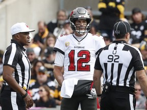 Tampa Bay Buccaneers quarterback Tom Brady (12) talks with referee Shawn Smith (left) and umpire Bryan Neale (92) against the Pittsburgh Steelers during the third quarter at Acrisure Stadium Oct 16, 2022. Pittsburgh won 20-18.