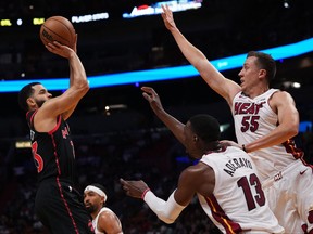 Raptors guard Fred VanVleet (23) shoots the ball over center Bam Adebayo (13) and Miami Heat guard Duncan Robinson (55) during the first half in Miami on Monday night.