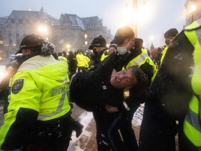 Police make an arrest after a person interfered with a police operation, on the 21st day of a protest against COVID-19 measures that has grown into a broader anti-government protest, in Ottawa, on Thursday, Feb. 17, 2022. THE CANADIAN PRESS/Justin Tang