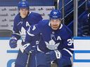 Auston Matthews i Mitchell Marner z Toronto Maple Leafs uderzyli na lód, aby zagrać przeciwko Montreal Canadiens w meczu 5 pierwszej rundy play-off 2021 Stanley Cup na Scotia Bank Arena 27 maja 2021 w Toronto, Ontario, Kanada. 
