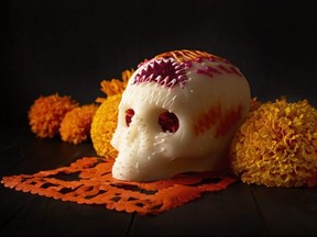 Sugar skull with Cempasuchil flowers or Marigold and Papel Picado. Decoration traditionally used in altars for the celebration of the day of the dead in Mexico.