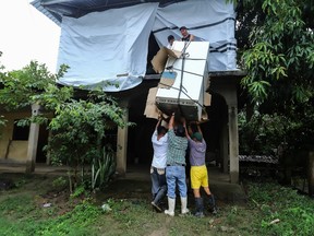 Anwohner entfernen einen Kühlschrank aus ihrem Haus, weil der Fluss Chamelecon in der Gemeinde La Lima, Departement Cortes, Honduras, überlaufen könnte.