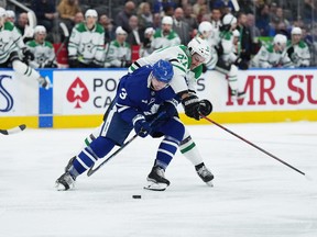 Maple Leafs' Justin Holl (left) battles for the puck with Dallas Stars' Mason Marchment during the second period at Scotiabank Arena on Thursday, Oct. 20, 2022.