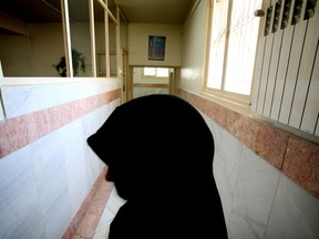 A female prison guard stands along a corridor in Tehran's Evin prison June 13, 2006.
