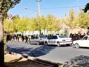 Protesters donning black march down the street following the death of Mahsa Amini in Saqez in Kurdistan Province, Iran Oct. 4, 2022 in this screengrab obtained by Reuters from a social media video.