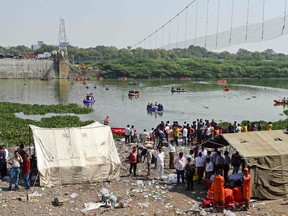 Rescue personnel conduct search operations after a bridge across the river Machchhu collapsed at Morbi on October 31, 2022.