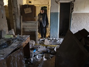 A man who claims to be a former prisoner, tortured with electric shocks by the Russian military, checks the debris inside a destroyed Russian command center on September 29, 2022 in Izium, Ukraine.