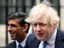 In this file photo taken Dec. 1, 2021 Britain's then Prime Minister Boris Johnson (right) stands with Britain's former Chancellor of the Exchequer Rishi Sunak during a meeting with entrepreneurs at Downing Street in London.