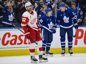 Toronto Maple Leafs centre Denis Malgin (62)  celebrates his goal with defenceman Justin Holl as Detroit Red Wings defenceman Jordan Oesterle looks on during the second period on Saturday at Scotiabank Arena.