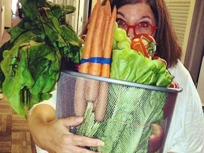 Rita DeMontis holding a large container of fresh produce purchased when food shopping was fun.