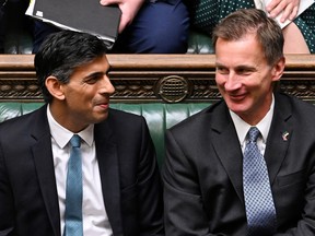 A handout photograph released by the U.K. Parliament shows Britain's Prime Minister Rishi Sunak, left, and Britain's Chancellor of the Exchequer Jeremy Hunt during Sunak's first Prime Minister's Questions (PMQs) in the House of Commons in London on Oct. 26, 2022.
