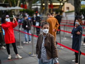 People wait in a line to test for Covid-19 in the Jing'an district in Shanghai on October 25, 2022.