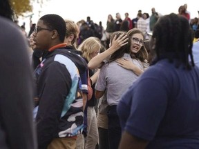 People gather outside after a shooting at Central Visual and Performing Arts high school in St. Louis, Monday, Oct. 24, 2022.