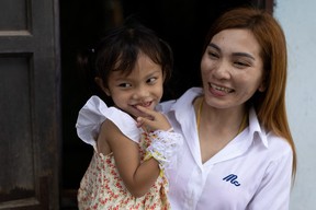 Panompai Sithong hält die Tochter Paveenut Supolwong mit dem Spitznamen Ammy, die das einzige Kind ist, das die Massenschießerei in der Kindertagesstätte überlebt, während eines Familientreffens in ihrem Haus in Uthai Sawan, Provinz Nong Bua Lam Phu, Thailand, am 9. Oktober 2022.