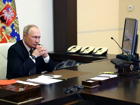 Russian President Vladimir Putin chairs a meeting with members of the Security Council via a video link at a residence outside Moscow, Oct. 19, 2022.