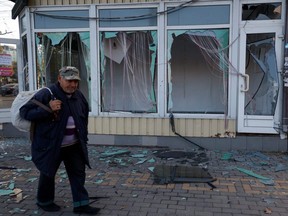 A man walks past a shop damaged by an explosion, amid Russia's attack on Ukraine, in Mykolaiv, Thursday, Oct. 20, 2022.