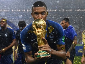 France's forward Kylian Mbappe kisses the World Cup trophy after winning the Russia 2018 World Cup final football match between France and Croatia at the Luzhniki Stadium in Moscow on July 15, 2018.