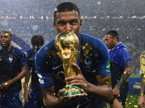 France’s forward Kylian Mbappe kisses the World Cup trophy after winning the Russia 2018 World Cup final football match between France and Croatia at the Luzhniki Stadium in Moscow on July 15, 2018.