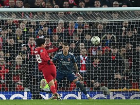 Liverpool's Japanese midfielder Takumi Minamino (L) hits the ball high over the bar with the goal at his mercy during the English League Cup semi-final first leg football match between Liverpool and Arsenal at Anfield in Liverpool, north west England on January 13, 2022.