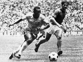 (FILES) This file photo taken on June 21, 1970 shows Brazilian midfielder Pele (L) dribbling past Italian defender Tarcisio Burgnich during the World Cup final in Mexico City. FILE / Getty Images