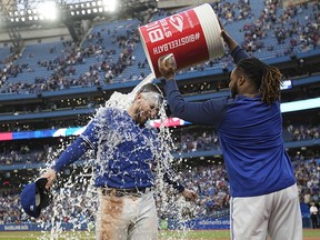 Oct 1, 2022; Toronto, Ontario, CAN; Toronto Blue Jays first baseman Vladimir Guerrero Jr., right, dumps a bucket of ice water over catcher Danny Jansen after a win over the Boston Red Sox at Rogers Centre.