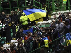 Spectators wave Ukrainian flag before the start of the Champions League Group F soccer match between Celtic and Shakhtar Donetsk at Celtic park, Glasgow, Scotland, Tuesday, Oct. 25, 2022.