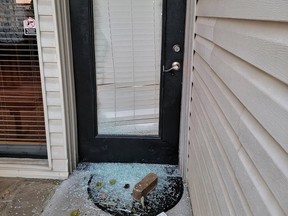 Door with shattered window and broken glass.