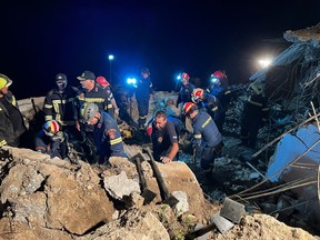 Firemen search in debris after a landslide in Agia Fotia, near Koutsounari, southeastern Crete, on Oct. 30, 2022.