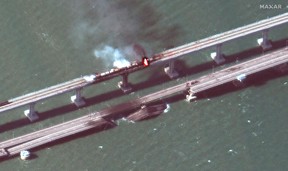 This handout satellite image taken and released by Maxar Technologies on Oct. 8, 2022, shows smoke billowing from a fire on the Crimea Bridge (also known as the Kerch Bridge) that links Crimea to Russia, after a truck exploded, near Kerch.