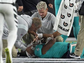 Le quart-arrière des Dolphins de Miami, Tua Tagovailoa, est examiné au cours de la première moitié du match de football de l'équipe de la NFL contre les Bengals de Cincinnati, le jeudi 29 septembre 2022, à Cincinnati.